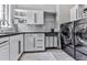 Well-organized laundry room with modern washer and dryer, shelving, and ample counter space at 5039 Towne Lake Hills North, Woodstock, GA 30189