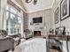 Cozy living room with a fireplace, comfortable seating, and a large window at 5039 Towne Lake Hills North, Woodstock, GA 30189