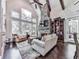 Inviting living room featuring a stone fireplace, vaulted ceiling, and large windows at 5039 Towne Lake Hills North, Woodstock, GA 30189