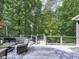 Outdoor living area features wood deck, seating, and wooded view at 5039 Towne Lake Hills North, Woodstock, GA 30189