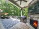 Outdoor living area features stone fireplace, grill, and covered patio at 5039 Towne Lake Hills North, Woodstock, GA 30189