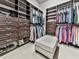 Spacious walk-in closet with custom shelving, drawers, and an ottoman for added convenience at 5039 Towne Lake Hills North, Woodstock, GA 30189