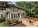 This backyard showcases a patio with seating, mature landscaping, and a traditional-style home facade at 5860 Fairway View Dr, Suwanee, GA 30024