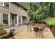 Cozy backyard patio area with gravel, seating, and a fire pit, surrounded by lush greenery at 5860 Fairway View Dr, Suwanee, GA 30024