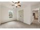 Neutral bedroom with a ceiling fan, a window with green views, a double door closet and carpet flooring at 5860 Fairway View Dr, Suwanee, GA 30024