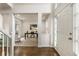 Inviting foyer featuring hardwood floors, a staircase, and view into living room with white walls and trim at 5860 Fairway View Dr, Suwanee, GA 30024