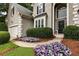 Home's manicured front entrance with colorful floral arrangements and well-maintained shrubs enhancing curb appeal at 5860 Fairway View Dr, Suwanee, GA 30024