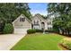 Charming two-story home with a well-manicured lawn, beautiful landscaping, and inviting curb appeal at 5860 Fairway View Dr, Suwanee, GA 30024