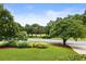 Manicured front yard featuring a well-maintained lawn, mature trees, and thoughtfully arranged shrubbery at 5860 Fairway View Dr, Suwanee, GA 30024