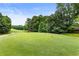 A wide shot of a lush green golf course with trees in the background, offering a scenic view at 5860 Fairway View Dr, Suwanee, GA 30024