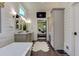 Bathroom featuring double sinks, bathtub, and view to bedroom through an open doorway at 125 Foxridge Rd, Atlanta, GA 30327
