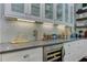 Close-up of a kitchen counter with stainless steel appliances, a wine cooler, and custom lighting at 125 Foxridge Rd, Atlanta, GA 30327