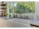 Close up of farmhouse kitchen sink under a large window looking out into the wooded property at 125 Foxridge Rd, Atlanta, GA 30327