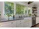 Farmhouse kitchen sink under a large window looking out into the wooded property at 125 Foxridge Rd, Atlanta, GA 30327