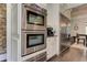 Modern kitchen featuring double ovens, a built-in refrigerator, and sleek white cabinetry at 125 Foxridge Rd, Atlanta, GA 30327