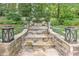 Inviting stone steps with lanterns, leading to a secluded seating area surrounded by mature landscaping at 125 Foxridge Rd, Atlanta, GA 30327