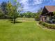 Lush front yard with mature trees and a well-maintained lawn leading to the home at 3769 Bay Creek Church Rd, Loganville, GA 30052