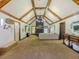 Spacious living room with vaulted ceiling, exposed beams, stone fireplace, and neutral decor at 3769 Bay Creek Church Rd, Loganville, GA 30052