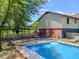 In-ground swimming pool with a small deck and seating area by a fenced yard at 3769 Bay Creek Church Rd, Loganville, GA 30052