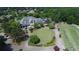 Aerial view of golf course featuring putting green and clubhouse with lake views in a luxury community at 8970 Moor Park Run, Duluth, GA 30097