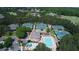 Aerial view of community pool, tennis courts, and clubhouse surrounded by mature trees and landscaping at 8970 Moor Park Run, Duluth, GA 30097
