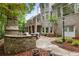 Charming backyard with a stone fireplace, patio, manicured landscaping, and access to the main house at 8970 Moor Park Run, Duluth, GA 30097