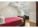 Cozy bedroom with a sloped ceiling, red comforter, hardwood floors, and a built-in desk at 8970 Moor Park Run, Duluth, GA 30097
