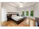 Bedroom featuring hardwood floors, a ceiling fan, large windows, and modern decor for ultimate relaxation at 8970 Moor Park Run, Duluth, GA 30097