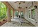 Spacious covered patio featuring brick arches, ceiling fans, stone flooring, and a spiral staircase at 8970 Moor Park Run, Duluth, GA 30097