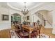 Traditional dining room featuring a wooden table, chandelier, and elegant staircase access at 8970 Moor Park Run, Duluth, GA 30097