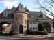 Stone clad entrance to community featuring arched entryway, tower and manicured landscaping at 8970 Moor Park Run, Duluth, GA 30097