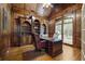 Wood paneled office with hardwood floors, built-in bookshelves and a large desk at 8970 Moor Park Run, Duluth, GA 30097