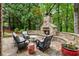 Inviting outdoor stone fireplace with seating area, perfect for entertaining in a lush backyard at 8970 Moor Park Run, Duluth, GA 30097