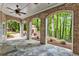 Covered stone patio with brick arches and stone fireplace overlooks wooded backyard at 8970 Moor Park Run, Duluth, GA 30097
