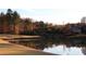 Scenic view of golf course pond and sand trap with luxury home in the distance and mature trees at 8970 Moor Park Run, Duluth, GA 30097