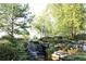 Landscaped waterfall feature and pond in a serene community setting at 8970 Moor Park Run, Duluth, GA 30097