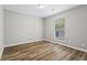 Bright bedroom features hardwood floors, a ceiling light, and large window for natural light at 1360 Terramont Dr, Roswell, GA 30076