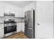 Well-lit kitchen features white cabinets, stainless steel appliances, and wood flooring at 1360 Terramont Dr, Roswell, GA 30076