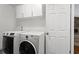Well-lit laundry room with modern washer and dryer units and overhead cabinets at 1360 Terramont Dr, Roswell, GA 30076