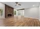 Spacious living room featuring hardwood floors, a stone fireplace, and contemporary ceiling fan at 1360 Terramont Dr, Roswell, GA 30076