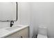 Modern powder room with sleek vanity, white countertop, a decorative mirror, and toilet at 367 Parkway Ne Dr # 5, Atlanta, GA 30312