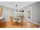 Bright dining area with wood floors, unique table, and glass door leading to the backyard at 5365 Glenhaven Dr, Cumming, GA 30041