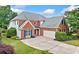 Attractive brick home with manicured lawn and extended driveway; complemented by mature trees and shrubbery at 5365 Glenhaven Dr, Cumming, GA 30041
