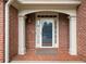 Close-up of a brick entryway featuring white trim, glass door, brick landing, and side window at 5365 Glenhaven Dr, Cumming, GA 30041