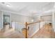 Bright upstairs hallway featuring wood floors, white railings, and a decorative chandelier at 5365 Glenhaven Dr, Cumming, GA 30041