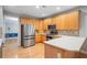 Well-lit kitchen featuring stainless steel appliances, light wood cabinets, and a contrasting tiled backsplash at 5365 Glenhaven Dr, Cumming, GA 30041