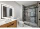 Modern bathroom features a sleek glass shower, wood vanity, and well-lit LED mirror at 942 Fairfield, Marietta, GA 30068