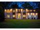 Exterior of home at dusk featuring professional lighting, white brick, wood accents, and green lawn at 942 Fairfield, Marietta, GA 30068