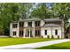 Stunning two-story home with white brick, wood accents, lush lawn, and a concrete driveway at 942 Fairfield, Marietta, GA 30068