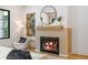 Bright room showcasing a modern fireplace with wood surround, round mirror, and stylish decor at 942 Fairfield, Marietta, GA 30068